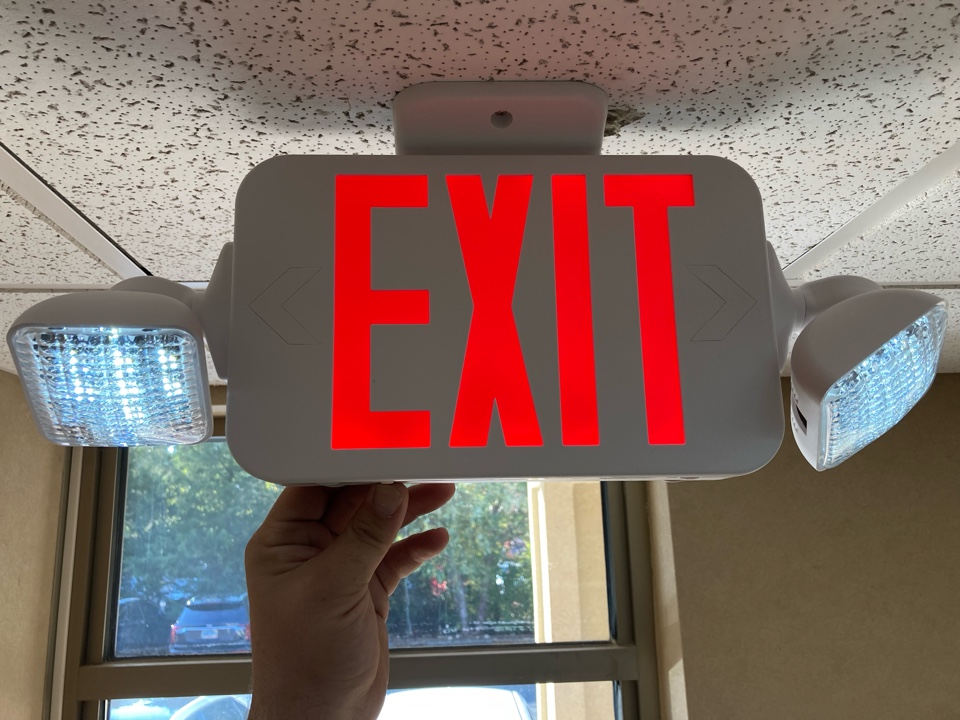 Electrician replacing an outdated exit sign