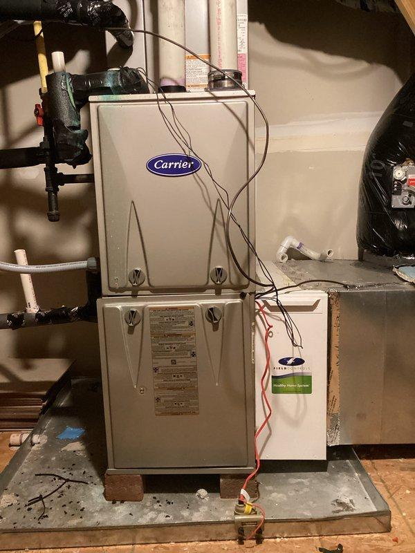 Responded to new customer complaint regarding 13-year-old dual zone HVAC system with upstairs zone set to 68°F but reading 80°F and not shutting off. Diagnosed Carrier system with Field Controls Healthy Home System attachment. Performed diagnostic testing with multimeter on control board and verified temperature readings. Collected $89 for service call plus repair and troubleshooting fees.