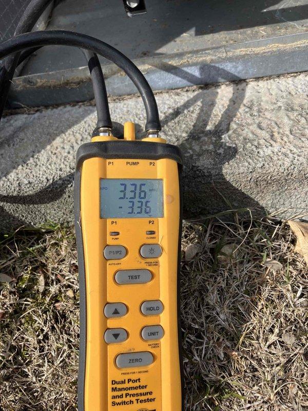 Installed customer-provided thermostat as requested. Performed system pressure testing using dual port manometer, confirming readings of 3.36 on both ports which indicates proper system balance. Inspected vapor barrier integrity in utility area where system components are housed.