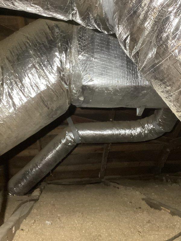 Performed diagnostic inspection on 11-year-old HVAC system after customer reported weak airflow and cold air concerns. Examined attic ductwork system, including main plenum and flexible ducts, noting proper installation but identifying restricted airflow to kitchen and bathroom zones. Adjusted dampers to improve distribution balance and restore proper temperature regulation.