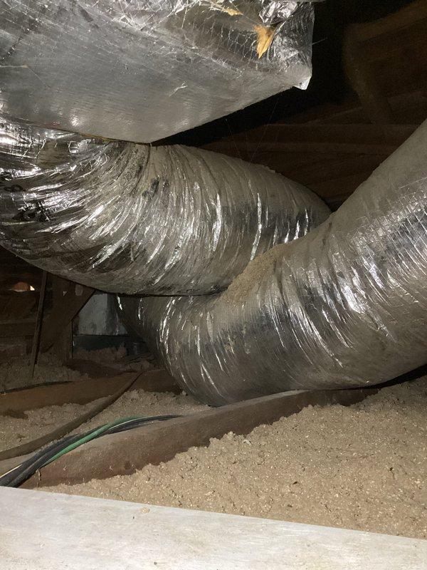 Performed diagnostic inspection on 11-year-old HVAC system after customer reported weak airflow and cold air concerns. Examined attic ductwork system, including main plenum and flexible ducts, noting proper installation but identifying restricted airflow to kitchen and bathroom zones. Adjusted dampers to improve distribution balance and restore proper temperature regulation.