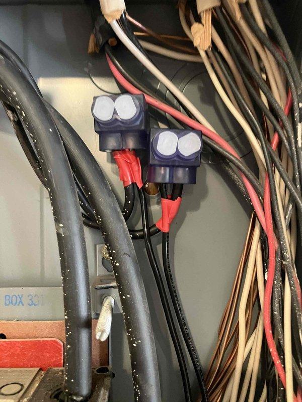 Conducted inspection of electrical wiring installation to address possible recall concern. Examined junction area containing blue wire connectors with white caps joining multiple wires (red/black). Verified calibration of measurement tool against specifications to ensure system compliance with safety standards.