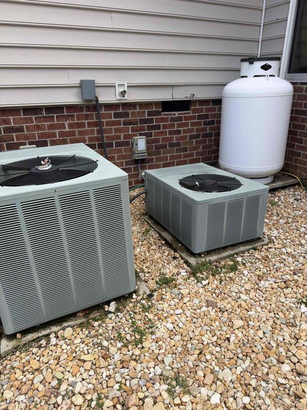Conducted comprehensive assessment of two 20+ year-old R22 HVAC systems with visible rust damage on one coil. Documented existing units with photographs showing outdoor condensers installed on gravel bed adjacent to house with vinyl/brick exterior. Presented customer with replacement options along with repair alternatives for comparison, particularly focusing on the 19-year-old unit showing deterioration.