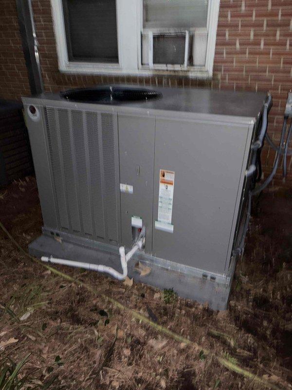 Completed installation of a new HVAC system with both interior and exterior components. The interior unit was installed in the crawlspace with proper electrical connections and drainage lines, while the exterior condensing unit was mounted on a concrete pad adjacent to the brick exterior wall with PVC condensate lines properly routed.