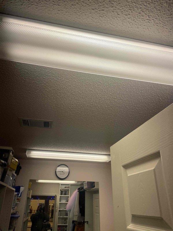 Completed conversion of 100 fluorescent light fixtures to LED across six areas: Room 1 (24), Room 2 (48), Room 3 (20), Faculty (2), Dressing Room (4), and Kitchen (2). Documented installation with photographs showing ceiling-mounted fixtures with prismatic diffusers and verified proper illumination throughout the commercial space.