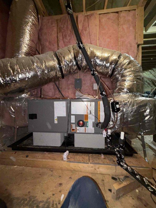 Successfully installed a Rheem outdoor condenser unit on concrete pad with proper line connections, along with interior air handler mounted on wooden platform in attic space. Complete system installation included running and securing insulated flexible ductwork throughout attic with all necessary electrical connections tested and verified for optimal operation.