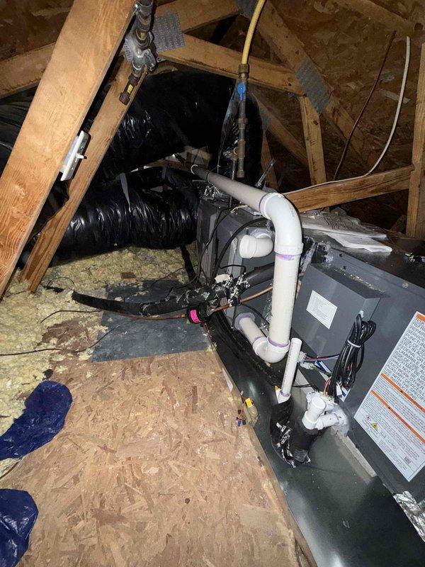 Performed follow-up service to address potential recall issue by inspecting HVAC system installation in attic space. Evaluated existing emergency drain pan configuration and determined replacement/modification needed to properly extend coverage beneath both furnace and evaporator coil components. Documented current installation condition with detailed photographs showing the unit, connections, and surrounding structural elements for warranty documentation.