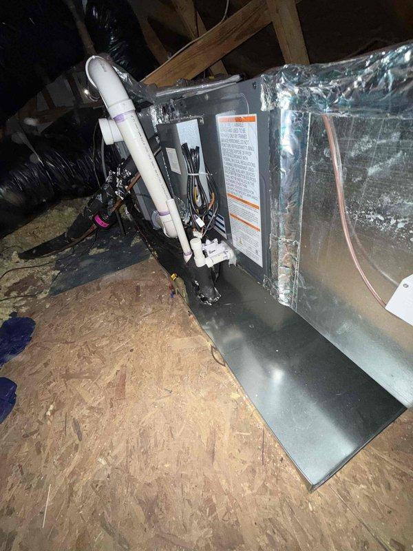 Performed follow-up service to address potential recall issue by inspecting HVAC system installation in attic space. Evaluated existing emergency drain pan configuration and determined replacement/modification needed to properly extend coverage beneath both furnace and evaporator coil components. Documented current installation condition with detailed photographs showing the unit, connections, and surrounding structural elements for warranty documentation.
