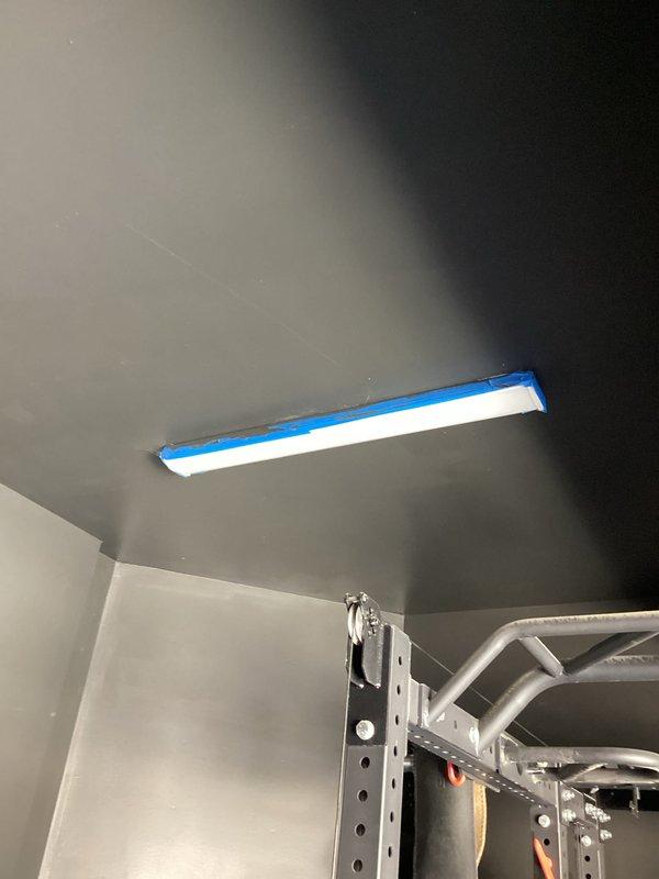 Completed replacement of two existing 4-foot garage strip lights with new 8-foot strip lights, and installed circuit extension from existing garage lighting to accommodate two additional 8-foot strip lights. Installation completed without incident; ceiling and surrounding area properly prepared with painter's tape to protect surfaces during work.