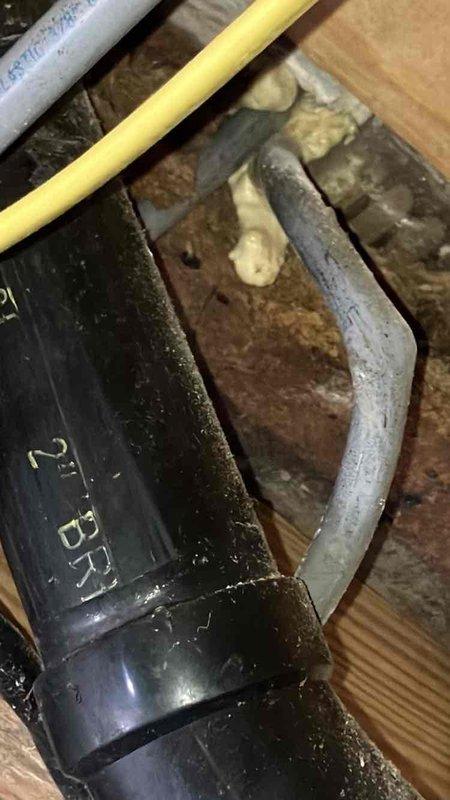 Inspected dryer vent installation and identified improper venting configuration. Documented issues with black PVC pipe connections in crawlspace, noting potential drainage concerns at T-junction connection where highlighted in documentation photos. Recommended proper venting modification to ensure code compliance and prevent potential hazards.