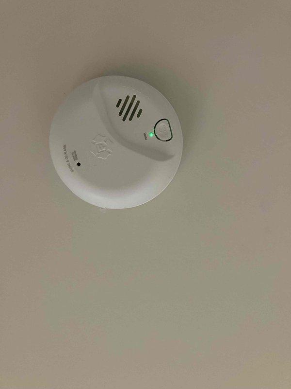 Responded to a service call regarding an electrical outlet that sparked at garbage disposal and flickering bathroom light despite bulb replacement. Upon inspection, found exposed wiring around light switches requiring proper installation of cover plates. Also observed operational smoke detector with functioning indicator light. Repaired faulty outlet connection at disposal, secured loose wiring at switch location, and installed proper cover plates to ensure safety compliance.