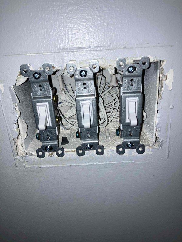 Responded to a service call regarding an electrical outlet that sparked at garbage disposal and flickering bathroom light despite bulb replacement. Upon inspection, found exposed wiring around light switches requiring proper installation of cover plates. Also observed operational smoke detector with functioning indicator light. Repaired faulty outlet connection at disposal, secured loose wiring at switch location, and installed proper cover plates to ensure safety compliance.