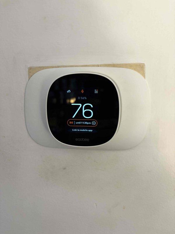 Successfully installed and configured a smart thermostat system with Wi-Fi connectivity. The unit was properly mounted on the wall, calibrated to maintain 76°F current temperature with a programmed setpoint of 68°F until 1:32pm, and linked to the mobile application for remote control capabilities.