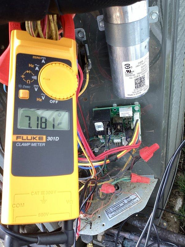 Diagnosed tripped breaker and performed electrical testing on the HVAC system using a Fluke 301D meter. Testing revealed capacitor reading of 7.181 μF, significantly below normal operating parameters, while amperage reading was 44.23, indicating electrical stress on the system. Replaced faulty capacitor, reset breaker, and verified proper system operation, restoring heat functionality.