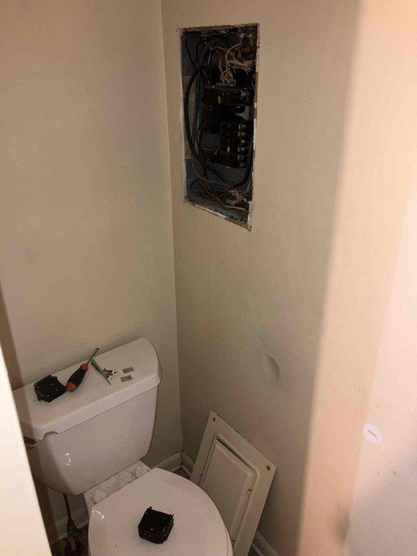 Responded to service call regarding buzzing circuit breaker. Upon inspection, discovered improperly installed electrical panel located above toilet with disorganized wiring connections. Documented extensive cobweb accumulation in crawl space indicating lack of regular maintenance. Discussed findings and recommended electrical panel relocation with property owner.