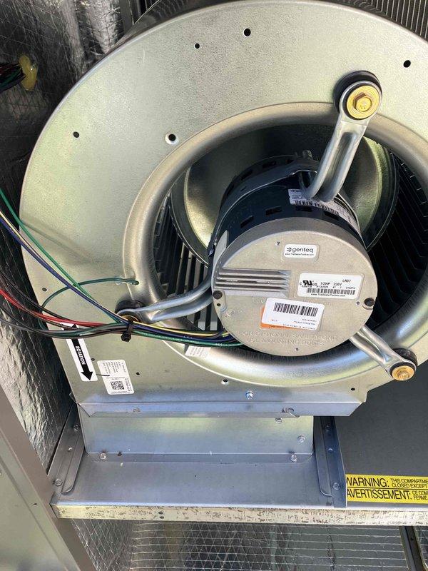 Responded to service call for non-operational thermostat and no heat. Upon inspection, found issues with the Genteq blower motor assembly in the air handler unit. Examined electrical connections at the terminal block where multiple colored wires (green, blue, red, black, and brown) connect to the motor. Documented condition with photos of the blower motor assembly and wiring connections for potential recall verification. System was restored to proper operation.