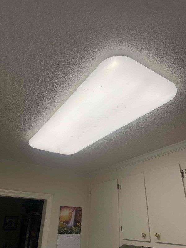 Responded to service call at 1998-built residence for multiple electrical issues including non-functional vent hood, overhead kitchen light, and outlet. Upon arrival, verified no tripped breakers at main panel. Troubleshot kitchen ceiling-mounted LED panel fixture and determined failure due to internal driver malfunction. Inspected range hood circuit and identified loose wire connection at junction box causing intermittent power loss. Investigated problematic outlet that homeowner had previously replaced; testing revealed backstab connection failure and downstream wiring fault causing repeated failure. Removed defective outlet, inspected branch circuit wiring, and discovered damaged conductor with evidence of arcing at wire connection point. Replaced damaged section of wiring, installed new commercial-grade outlet with screw terminal connections for reliable contact, and verified proper grounding. Replaced failed LED panel driver in kitchen ceiling fixture and confirmed proper operatio
