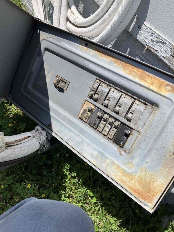 Responded to emergency electrical service call at 1940s-era rental property where vehicular impact caused complete detachment of exterior electrical panel and meter assembly from structure. Upon arrival, assessed extensive damage including displaced meter base, compromised electrical conduit runs, and service entrance conductors that had been pulled from their mounting points. Fire department had previously secured the scene and relocated damaged equipment from roadway back onto property.

Conducted thorough inspection of exterior electrical disconnect box and main panel, documenting severe rust and corrosion throughout interior components, particularly concentrated along bottom edges and mounting surfaces. Corrosion indicated prolonged moisture exposure predating the collision damage. Evaluated circuit breakers, interior panel surfaces, and weathered electrical components for serviceability.

Assessed damage to electrical conduit system, including sections running vertically to roofli