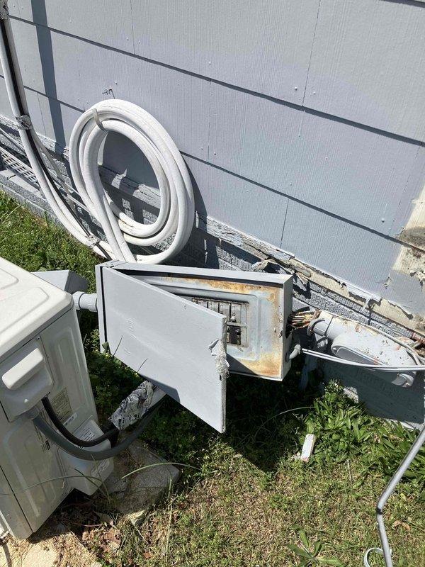 Responded to emergency electrical service call at 1940s-era rental property where vehicular impact caused complete detachment of exterior electrical panel and meter assembly from structure. Upon arrival, assessed extensive damage including displaced meter base, compromised electrical conduit runs, and service entrance conductors that had been pulled from their mounting points. Fire department had previously secured the scene and relocated damaged equipment from roadway back onto property.

Conducted thorough inspection of exterior electrical disconnect box and main panel, documenting severe rust and corrosion throughout interior components, particularly concentrated along bottom edges and mounting surfaces. Corrosion indicated prolonged moisture exposure predating the collision damage. Evaluated circuit breakers, interior panel surfaces, and weathered electrical components for serviceability.

Assessed damage to electrical conduit system, including sections running vertically to roofli