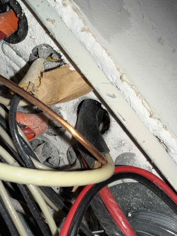Responded to service call regarding exposed live electrical wire at newly installed A.O. Smith ProMax water heater located in garage. Upon arrival, verified electrical hazard and safely de-energized circuit at main panel. Removed abandoned energized conductor that was left exposed during water heater installation, properly capped wire ends, and secured within junction box per NEC standards. Verified all electrical connections to water heater were properly terminated and grounded, restored power, and confirmed safe operation of unit.