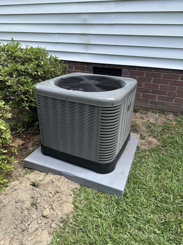 Completed installation of residential air conditioning condensing unit on exterior of property. Unit was positioned on new concrete pad adjacent to house foundation, with proper clearance from structure and landscaping for adequate airflow and future maintenance access. Connected refrigerant lines, electrical service, and verified system startup and operational parameters within manufacturer specifications.