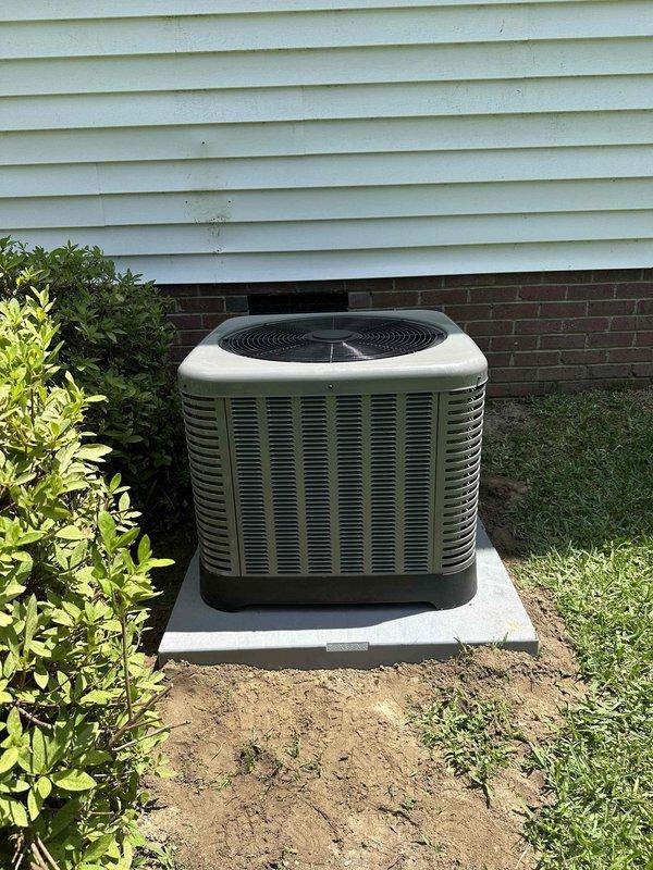Completed installation of residential air conditioning condensing unit on exterior of property. Unit was positioned on new concrete pad adjacent to house foundation, with proper clearance from structure and landscaping for adequate airflow and future maintenance access. Connected refrigerant lines, electrical service, and verified system startup and operational parameters within manufacturer specifications.