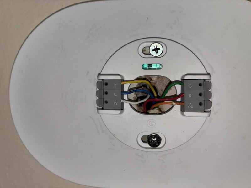 Conducted system replacement estimate for residential HVAC equipment. Documented existing return air grille location in main hallway and photographed current thermostat wiring configuration showing standard HVAC connections (Y, C, W, G, R, OB terminals) to ensure compatibility planning for new equipment installation.