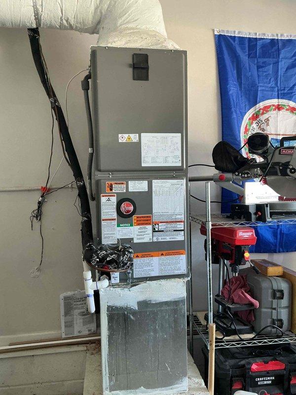 # HVAC System Installation

Successfully completed a full HVAC system installation consisting of a Rheem outdoor condensing unit and indoor air handler. The outdoor unit was positioned on a concrete pad on the side of the residence with proper clearances maintained. Electrical disconnect box was mounted to exterior wall with conduit run providing power to the unit. Inside the garage, installed a vertical air handler unit with appropriate ductwork connections including flexible supply ducting. All electrical wiring was secured and run according to code requirements. System was tested for proper operation, refrigerant levels verified, and all safety labels and manufacturer specifications confirmed visible and intact. Installation meets industry standards and manufacturer requirements for optimal system performance.