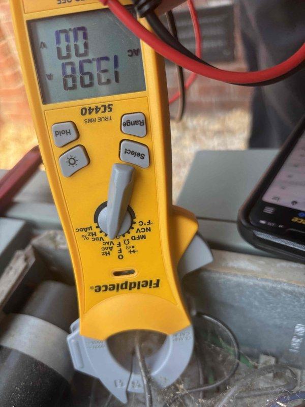 Responded to no cooling call on downstairs unit of a two-system residence with 20-year-old equipment. Upon arrival, performed diagnostic testing on the affected Rheem condensing unit using multimeter, which revealed a compressor issue with abnormal electrical readings of 86.61 ohms. Unit was blowing air but compressor was not operating, confirming customer's report of no cooling condition.