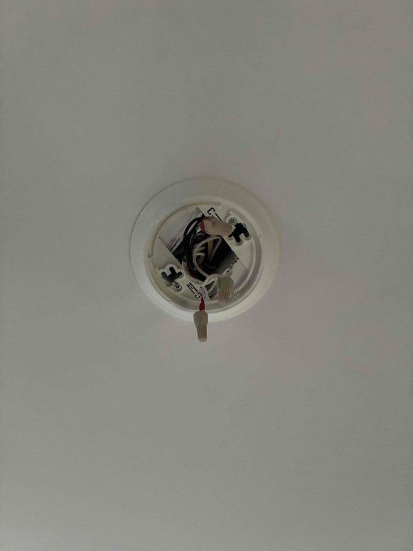 Responded to return visit for malfunctioning smoke detector that had been intermittently alarming since Thursday. Removed defective First Alert smoke detector from 12-foot ceiling and inspected hardwired electrical connections. Installed new smoke detector unit, secured wiring connections, tested device functionality, and verified proper operation of alarm system.