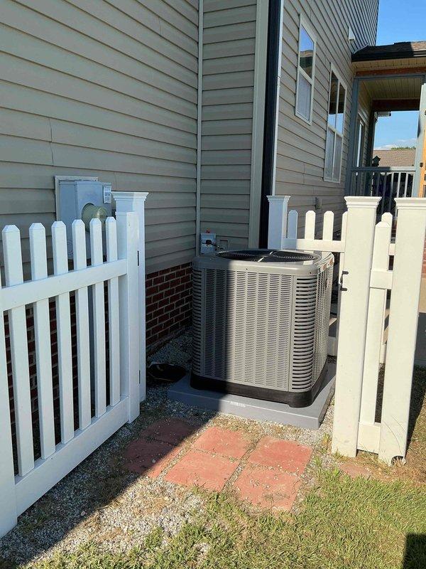 # HVAC Installation Summary

Successfully completed full residential HVAC system installation including outdoor condensing unit and indoor air distribution components. Positioned beige/tan air conditioning condenser unit on concrete pad in side yard location with proper clearances maintained despite confined space between structures. Installed flexible insulated ductwork throughout attic space with multiple branch runs from central plenum junction. Mounted and wired control unit to wooden support beam with proper electrical connections established. System installation financed through service financing program with down payment arrangement.

# Detailed Work Performed

Installed complete residential air conditioning system including outdoor and indoor components. Exterior condensing unit positioned on prepared concrete pad in narrow side yard area between two residential structures. Unit placement required careful consideration of spatial constraints with white vinyl picket fencing on b