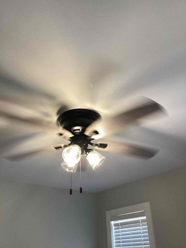 Completed follow-up installation of two customer-supplied ceiling fans in downstairs bedrooms after original units arrived damaged. Verified electrical junction boxes were properly rated and secured for fan support, then installed both multi-blade ceiling fans with integrated light kits featuring frosted glass shades and pull-chain controls. Both fans are operational with lighting functioning properly.