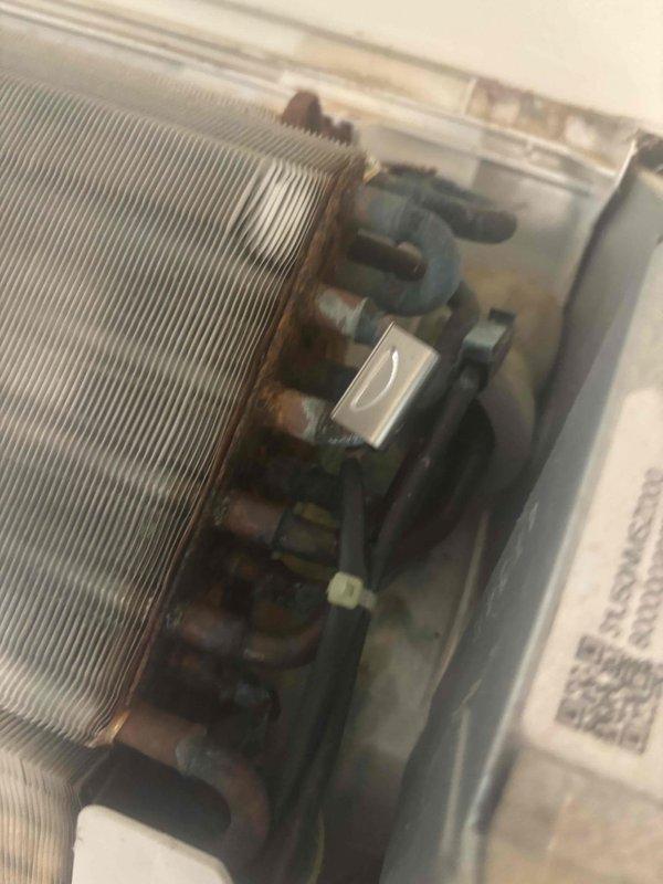 Responded to no cooling complaint on Mitsubishi Electric mini split system blowing ambient air only. Upon arrival, inspected indoor unit and verified remote control settings and operation. Examined outdoor unit heat exchanger coil and electrical connections, noting condition of components and wiring terminals. System evaluated and documented with photos of remote control display and outdoor unit coil assembly with electrical housing for further diagnostic assessment.