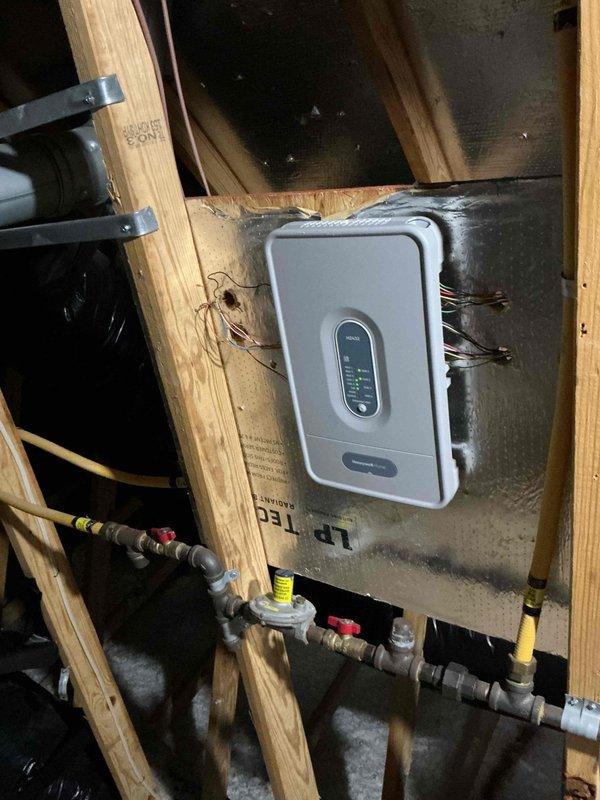 Completed HVAC system installation including gas line connections with shut-off valves and integrated electronic control unit mounted in utility space. Established electrical service by connecting new circuit breakers in main panel to support system operation, with all connections tested and verified operational.