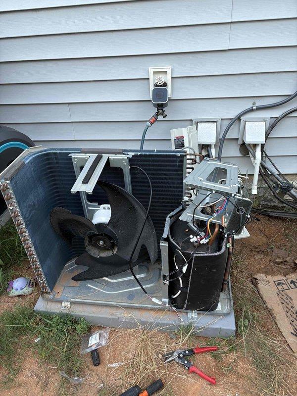 Performed warranty replacement on outdoor condensing unit components installed nine months prior. Replaced defective control board and outdoor fan motor. Disassembled condenser housing to access internal components, disconnected electrical connections, and removed failed circuit board and motor assembly. Installed new OEM control board and fan motor, reconnected all electrical wiring, and reassembled unit housing. Tested system operation to verify proper function of new components. Provided pricing information for optional surge protection kit installation upon customer request. Documented repairs with photographs of replaced control board and exposed condenser unit during service.
