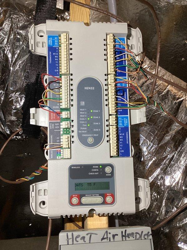 Responded to service call for high indoor humidity levels (53%) and recurring mold growth in air handler unit. Performed comprehensive system inspection of 6-year-old HVAC system to diagnose moisture issues and water accumulation in drain pipe and ductwork. 

Upon inspection, identified HZ432 zone control module with improper power configuration - system operating without dedicated transformer and stealing power from thermostat circuit, which can cause intermittent operation and control issues. Examined air handler drain pan installation and condensate drainage system to assess conflicting reports from previous technicians regarding proper installation. Documented control wiring configuration showing multiple zone connections and heating/cooling circuits.

Evaluated system operation and airflow to determine contributing factors to elevated humidity levels. Assessed air handler cabinet for evidence of moisture intrusion and mold growth patterns. Inspected condensate drain line routing a