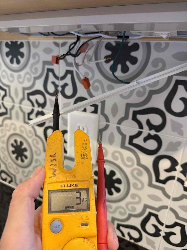 Responded to kitchen electrical issue affecting two light switches controlling the sink light and under-cabinet lighting in a 2022 home. Using a Fluke multimeter, tested voltage at the affected circuits and traced wiring connections behind the decorative tile backsplash. Identified loose wire connections at wire nuts in the junction box above the counter, re-secured all connections, verified proper voltage delivery, and restored full functionality to both lighting circuits.