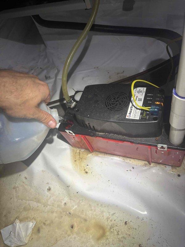 Responded to no-cool condition on downstairs unit of a two-system residence with 2021 equipment. Upon arrival, confirmed thermostat was set to 71°F but no airflow from registers and outdoor unit not energizing. Inspected air handler and found condensate pump failure causing safety float switch activation, which shut down system operation. Condensate drain pan showed significant sediment buildup and staining indicating prolonged water accumulation. Cleared blockage from condensate drain line, cleaned drain pan, and tested pump operation. Verified proper drainage flow through PVC condensate piping. Cycled system successfully with outdoor unit engaging and airflow restored to all registers. Upstairs unit operating normally with no issues noted.