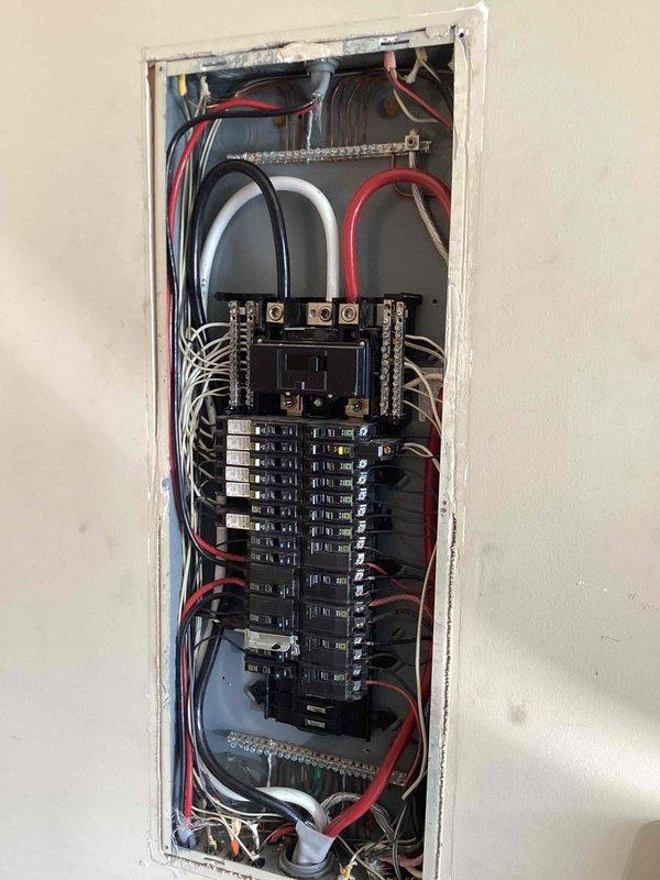 Completed comprehensive 32-point electrical system evaluation on 2014 home. Performed electrical panel maintenance including proper torquing of all breaker connections and verification of secure terminations at main breaker and branch circuits. Tested all GFCI shock protection outlets and breakers to confirm proper ground fault protection functionality. Verified operation of all AFCI fire protection breakers to ensure arc fault detection systems working correctly. Conducted smoke and carbon monoxide detector maintenance including battery replacement and alarm testing. Replaced customer-supplied light bulbs in fixtures up to 12 feet. Cleaned ceiling fans up to 12 feet in height. Documented electrical panel configuration showing main service entrance conductors, split-bus breaker arrangement, and proper neutral and ground bus bar connections. Inspected laundry room electrical outlet and washing machine water supply box installation. All electrical systems tested and confirmed operational