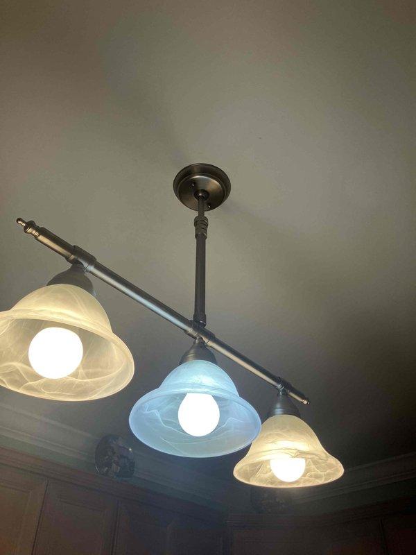 Responded to electrical service call for tripped breaker and chandelier appearing to disconnect from ceiling. Upon inspection, found ceiling-mounted light fixture with loose mounting hardware causing the fixture to hang lower than normal position. Verified electrical connections at junction box were secure, tightened fixture canopy and mounting rod assembly to ceiling plate, and confirmed proper fixture height and stability. Tested circuit breaker and fixture operation—all components functioning properly with no further tripping issues observed.