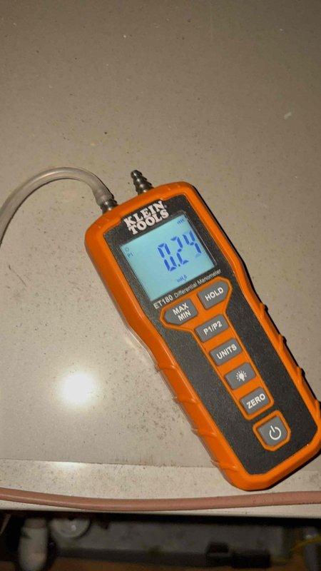 Responded to no cooling complaint affecting rear portion of residence. Found inadequate airflow to back zones while front and upstairs areas maintained proper air delivery. Performed static pressure diagnostics on air handler unit using digital manometer, recording 0.74" measurement. Inspected ductwork system and air handler located in basement area. Identified zoning system issue affecting one of three thermostats controlling the property. Verified proper operation of equipment and supply duct connections at main unit.