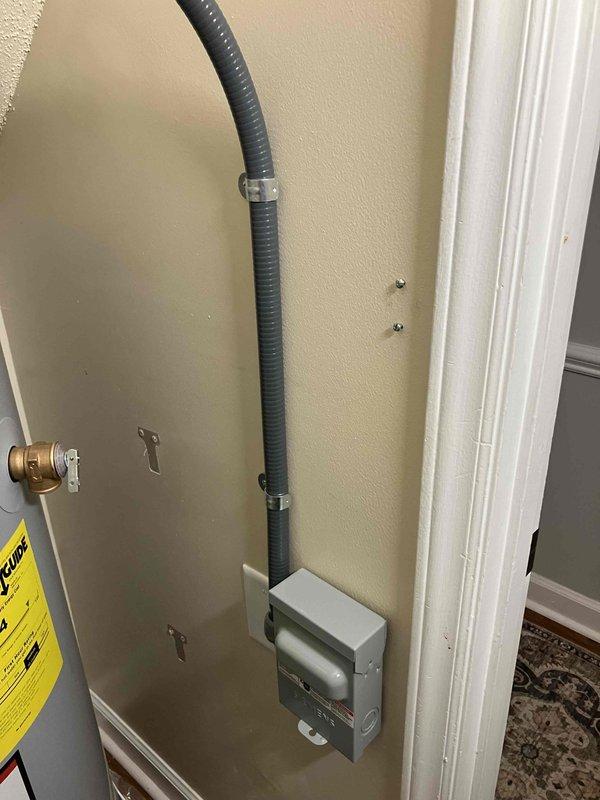 Installed dedicated electrical outlet and disconnect for new State ProLine commercial-grade water heater in 1985 residential home. Ran gray flexible conduit vertically along interior wall from new junction box to water heater location, secured with appropriate clips and clamps. Coordinated with plumbing team to ensure same-day completion and restore hot water service to residence.