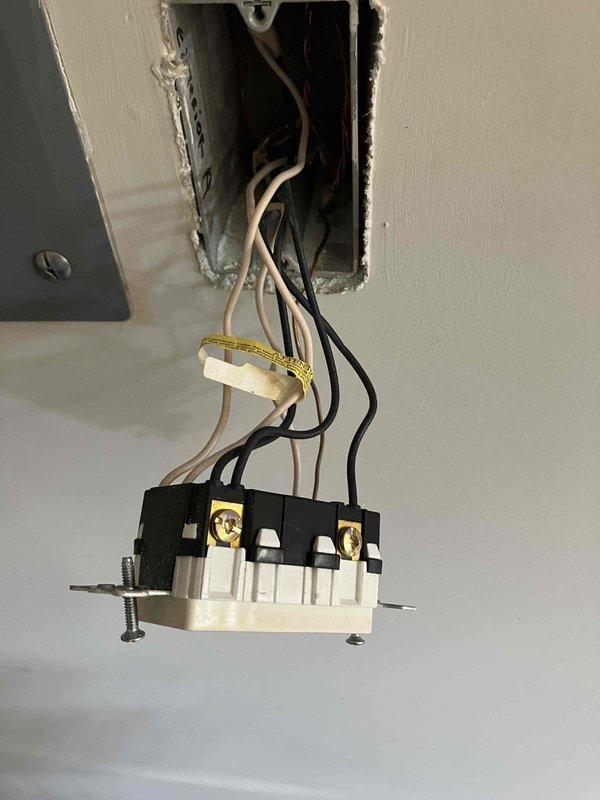 Responded to emergency service call for complete loss of power to major appliances in 2016 construction home. Inspected main electrical meter enclosure and found signs of deteriorated wiring connections at meter base with visible discoloration on conductor terminations, indicating potential overheating or arcing event. Documented Stratus IQ digital meter installation and noted utility company had previously investigated without identifying source of neighborhood-wide power quality issues. Evaluated affected circuit serving kitchen appliances where HVAC system, refrigerator, oven, and stove all failed simultaneously, suggesting power surge or phase loss event. Inspected ceiling-mounted light fixture with intermittent failure history and found loose wire connections at dimmer module requiring attention. Coordinated findings with municipal utility representatives onsite and recommended immediate follow-up for appliance damage assessment and potential utility-side service conductor or tran