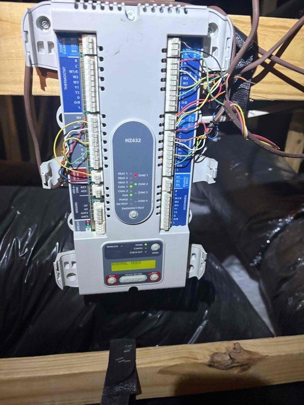 Responded to service call for bonus room experiencing inadequate cooling on a two-system residential property with 8-year-old equipment. Accessed attic space to investigate suspected damper malfunction affecting zone control. Inspected multi-zone HVAC control module (BZ432) and verified wiring connections, terminal strips, and system status displaying normal mode operation. Evaluated damper operation and zoning system functionality to determine cause of insufficient airflow to affected area. Documented system configuration with measurements and provided estimate for recommended repairs to restore proper zone temperature control.