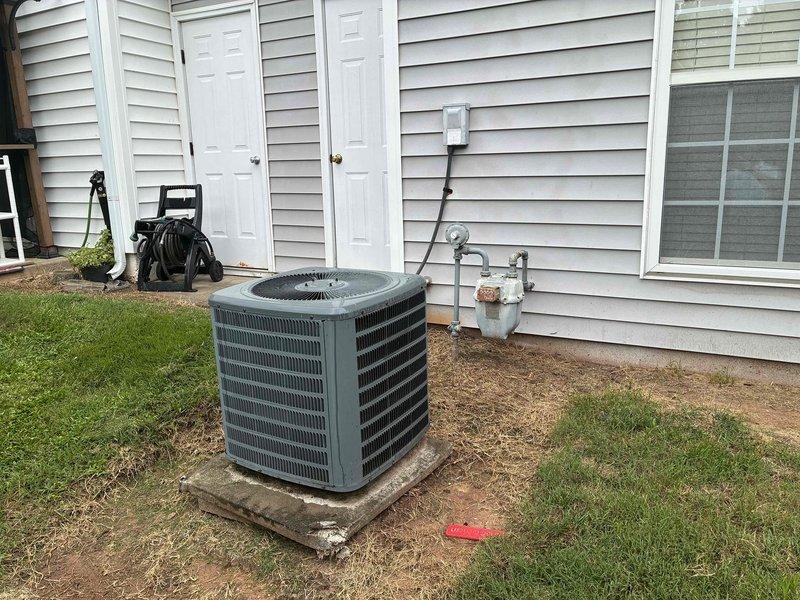 Conducted sales consultation for complete HVAC system replacement at residential property. Evaluated existing 22-year-old furnace and 14-year-old air conditioning system, both showing significant age-related wear. Inspected outdoor condenser unit positioned on concrete pad against exterior wall, noting standard residential installation with disconnect box and associated electrical components. Assessed attic-mounted air handler and ductwork configuration, observing corroded copper refrigerant lines and aged filter housing. Documented current equipment condition through photographs and discussed replacement options for both heating and cooling units with homeowner to address aging infrastructure and improve system efficiency.