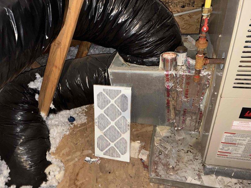 Conducted sales consultation for complete HVAC system replacement at residential property. Evaluated existing 22-year-old furnace and 14-year-old air conditioning system, both showing significant age-related wear. Inspected outdoor condenser unit positioned on concrete pad against exterior wall, noting standard residential installation with disconnect box and associated electrical components. Assessed attic-mounted air handler and ductwork configuration, observing corroded copper refrigerant lines and aged filter housing. Documented current equipment condition through photographs and discussed replacement options for both heating and cooling units with homeowner to address aging infrastructure and improve system efficiency.