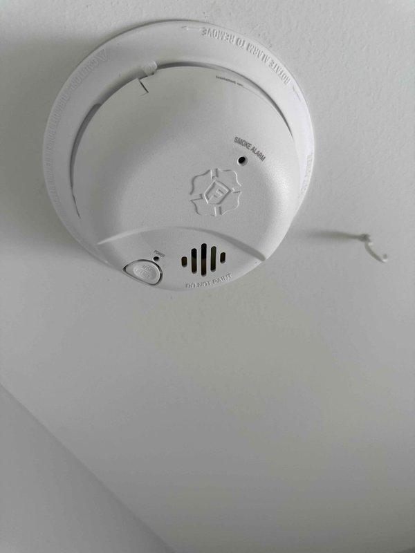 Responded to service call for smoke detector that emitted three beeps on second floor hallway of 2017-built residence. Inspected ceiling-mounted smoke alarm unit, verified proper mounting and physical condition, and tested functionality. Detector found to be operating within normal parameters with no defects observed.