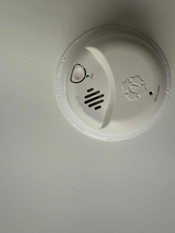 Responded to service call for smoke detector that emitted three beeps on second floor hallway of 2017-built residence. Inspected ceiling-mounted smoke alarm unit, verified proper mounting and physical condition, and tested functionality. Detector found to be operating within normal parameters with no defects observed.