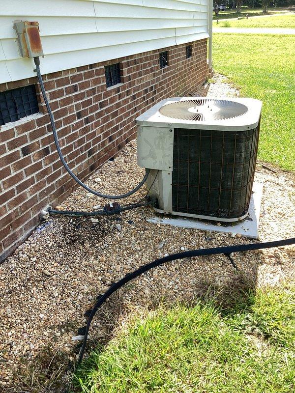Responded to customer request regarding reported hole in refrigerant line on 26-year-old air conditioning system. Upon arrival, conducted visual inspection of outdoor condensing unit and associated refrigerant lines. Inspected electrical disconnect, circuit breaker panel, and all accessible refrigerant line routing from outdoor unit to building penetration points. Documented current system condition with photographic evidence showing unit placement, line set configuration, and electrical components. Contacted customer to discuss findings and provided recommendations for refrigerant line replacement options based on observed system age and condition.
