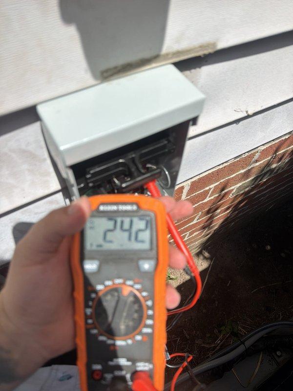 Installed dedicated electrical circuit for HVAC air conditioning unit, routing new wiring through attic space to exterior disconnect location. Verified proper voltage at 242V and confirmed all connections were secure and operational.